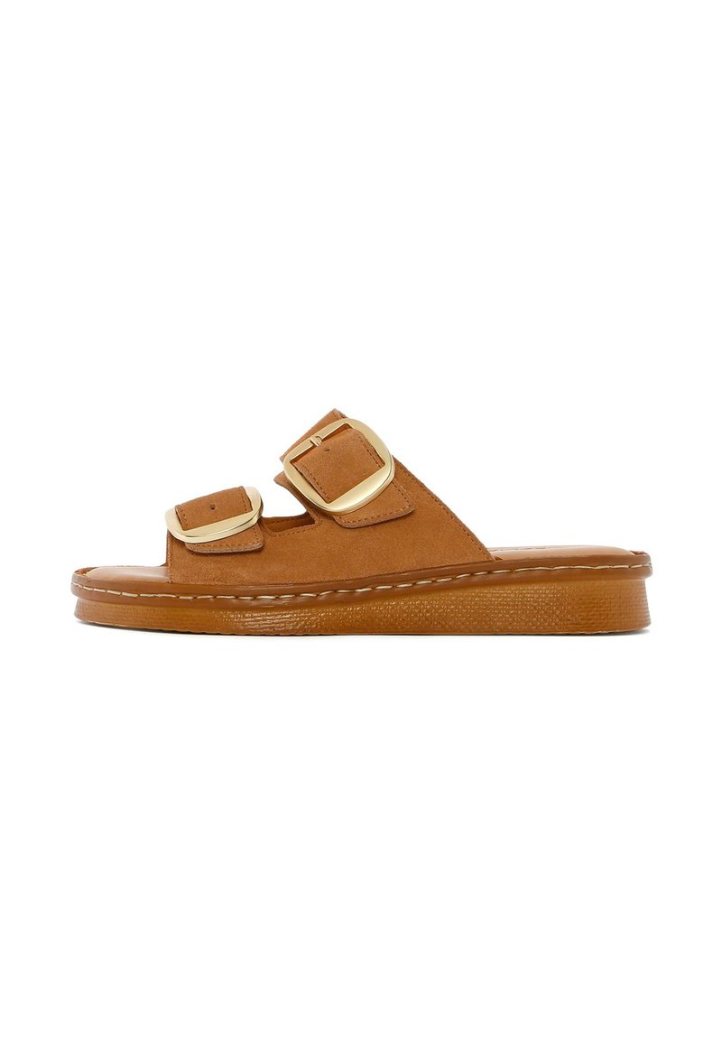 Bruine suède slidesandalen met twee verstelbare banden, gouden gespen, een gestructureerde zool en een dikke platte basis voor ondersteuning.