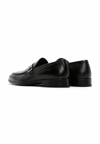 Zwarte leren loafers met een gestructureerde afwerking, voorzien van een zilveren gespaccent en een lage gestapelde hak. Gladde teenontwerp en ronde vorm.