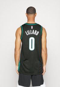 Maillot de basket-ball noir avec des accents en teal, affichant le nom "LILLARD" et le numéro "0" au dos. Texture en maille, design sans manches.