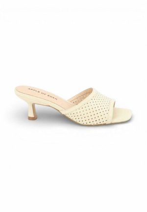 Beige open-toe mule sandaal met lage kittenhak en geperforeerd bovenwerk, merknaam "Apple of Eden" op de binnenzool.