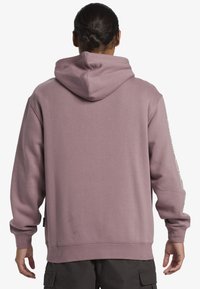 Purple, hooded sweatshirt with long sleeves and ribbed cuffs, featuring a logo along the left sleeve and soft, textured fabric.