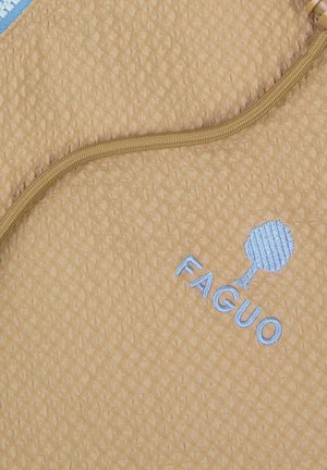 Tissu beige texturé avec un cordon de serrage marron et un logo d'arbre brodé en bleu clair au-dessus du mot "FAGUO".