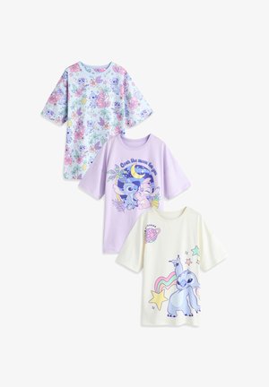 Trois t-shirts de couleur pastel avec des imprimés sur le thème Stitch : motif floral, scène nocturne "Over the moon for you" et arc-en-ciel avec des étoiles.