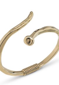 Brazalete de metal color dorado abierto, con un extremo redondeado, un detalle de espiral cerca de la apertura y una inscripción grabada en uno de los brazos.