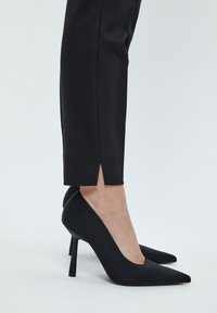 Minus MIDAYA PANTS 7/8 - Chinos tipa bikses - black