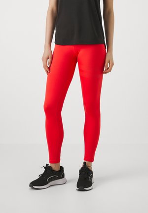 Røde treningsleggings laget av et elastisk materiale, med en glatt tekstur og en tettsittende design, kombinert med svarte joggesko.