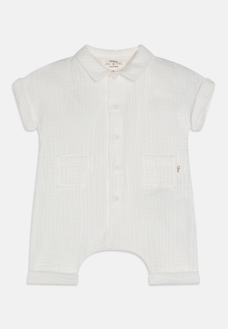 Combinaison en coton blanc avec des manches courtes retroussées, un devant à boutons, deux poches avant et un motif texturé subtil sur l'ensemble.