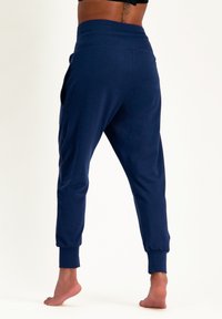 Marineblaue Jogginghosen aus weichem Stoff, mit entspannter Passform, schmal zulaufenden Knöcheln und seitlichen Taschen, sowie einem breiten, bequemen Bund.