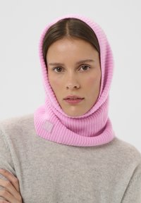Rózsaszín kötött kapucnis sál bordázott textúrával és behajtott kialakítással, elöl egy kis dombornyomott logóval.