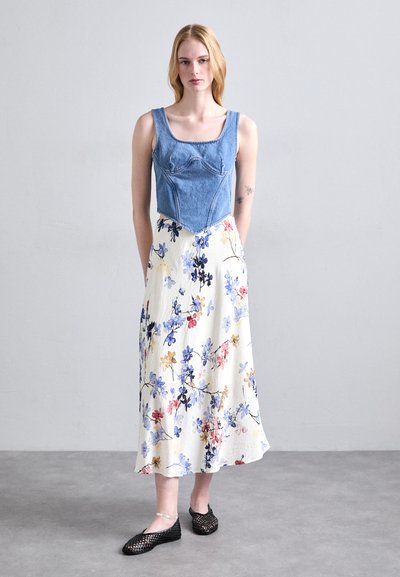 Denim bodice top med firkantet udskæring, hvid nederdel med blomsterprint, og sorte flettede flade sko. Glat tekstur og afslappet pasform hele vejen igennem.