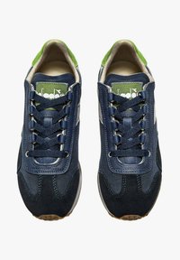 Baskets de sport bleu marine et vert en mélange de daim doux et de mesh, avec des lacets ronds et une languette rembourrée pour un confort accru.