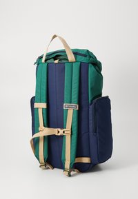 Zaino Columbia in blu e verde, dotato di spallacci regolabili, maniglia superiore, chiusura con zip e tasche esterne. Tessuto resistente.