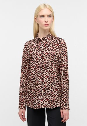 Blouse met luipaardmotief, met knopen aan de voorkant, lange mouwen, kraag en contrasterende roestkleurige zwarte vlekken op een beige achtergrond. Gladde stoftextuur.