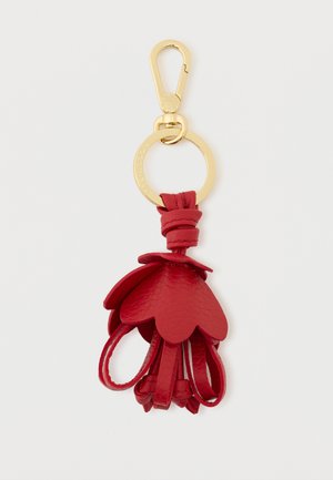 Punane nahast võtmehoidja, millel on kihilised õielehed, lõpetatud kullatud metallklambriga ja rõngaga kinnitamiseks.