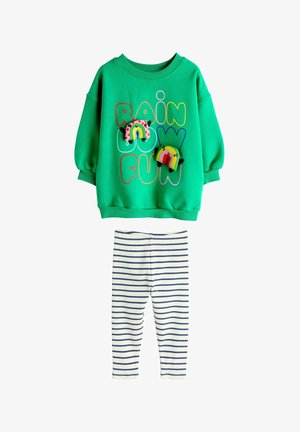 Zeleno majico z dolgimi rokavi s pisanimi napisi »RAINBOW FUN« in mavričnimi obliži, kombinirano z belimi legicami z mornarsko modrimi horizontalnimi črtami.