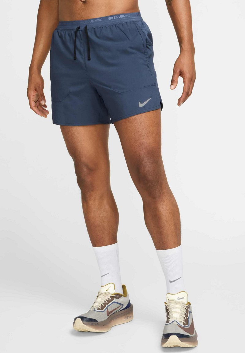 Pantalones cortos de running Nike en azul marino con cintura elástica y cordón ajustable, que cuentan con un bolsillo lateral y un logo reflectante, fabricados con tejido ligero.