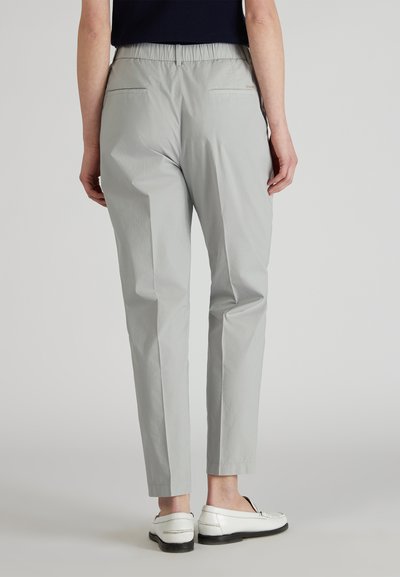 Pantalons fuselés gris clair avec une taille élastique, dotés de deux poches arrière et d'une texture de tissu lisse et légèrement brillante.