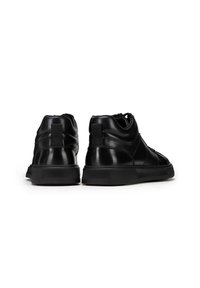 Black leather high-top sneakers featuring a textured finish, smooth accents, rubber soles, and a pull tab at the back for easy wear.