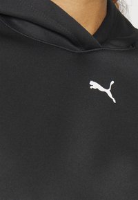 Felpa nera con cappuccio realizzata in tessuto liscio, dotata di tasca a marsupio. Presenta un logo bianco Puma sul davanti. L'apertura del cappuccio è strutturata.