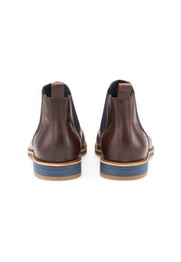 Brązowe skórzane botki za kostkę z elastycznymi panelami bocznymi, kontrastującą niebieską podeszwą środkową oraz beżową gumową podeszwą. Posiadają pętle ułatwiające zakładanie.