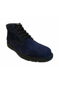 Botín de ante azul marino con cordones negros, puntera redonda y suela de goma. Presenta costuras en contraste y un collar acolchado para mayor comodidad.