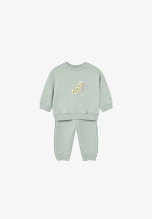 Completo felpa e pantaloni verde chiaro per bambino piccolo con piccolo disegno rosa di scivolo e scala e testo sul davanti della felpa.