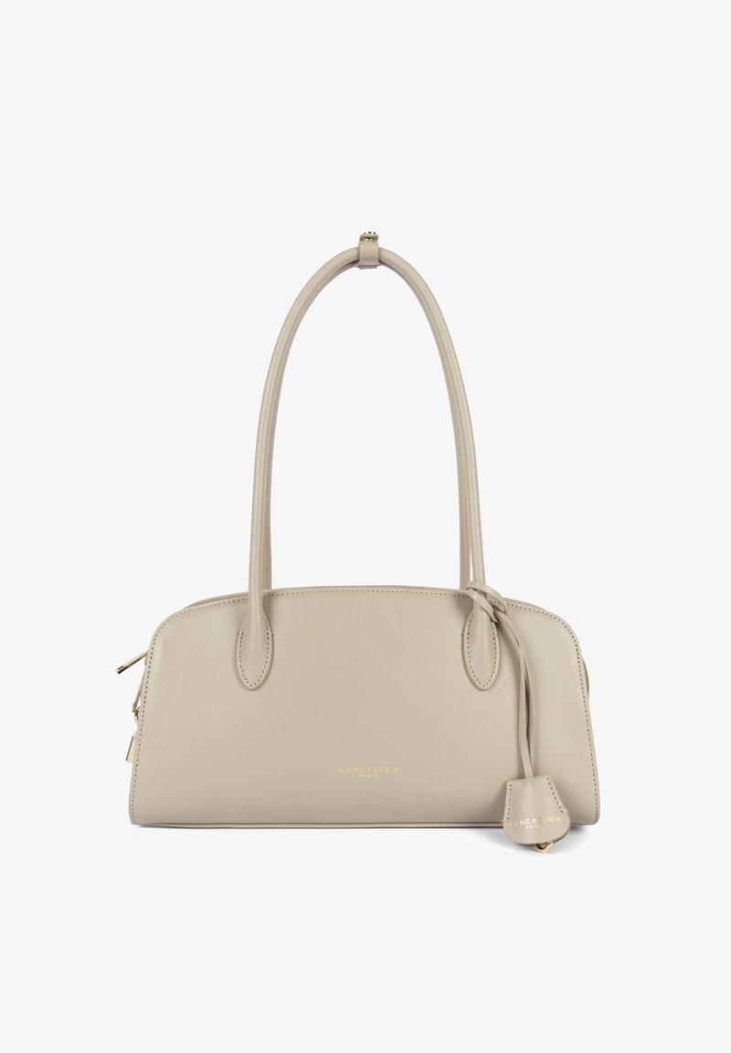 Sac à main en cuir beige avec poignées longues, fermeture éclair dorée et étiquette en cuir décorative embossée du nom de la marque "Lancaster Paris".