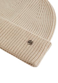 Berretto di maglia beige con un motivo a coste testurizzato, dotato di un accento in metallo sul risvolto e realizzato in morbida lana.