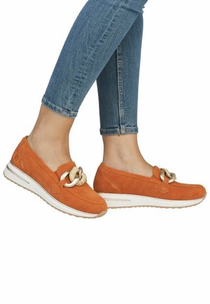 Scarpe slip-on in suede arancione con dettaglio a nodo in tessuto e suola in gomma bianca; presentano una punta tonda e dettagli cuciti.