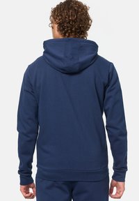 Felpa blu navy realizzata in tessuto misto cotone, con cappuccio regolabile, maniche lunghe e polsini e orlo a costine. Texture liscia.