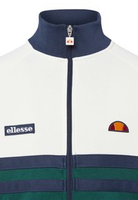 Biała kurtka rozpinana na zamek Ellesse z granatowym kołnierzem, ozdobiona zielonymi i granatowymi paskami, haftowanym logo oraz kolorowym akcentem na piersi. Wykonana z bawełnianej mieszanki.