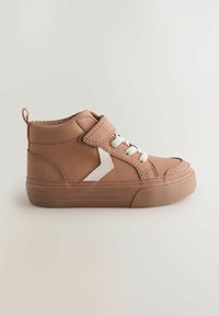 Baskets montantes marron avec lacets blancs et une sangle Velcro. Présente un détail zigzag de couleur claire sur le côté et une semelle en caoutchouc texturée.
