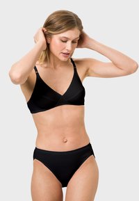 Black wireless bra and matching high-waisted panties, made of smooth fabric, featuring a scalloped edge and a simple design.