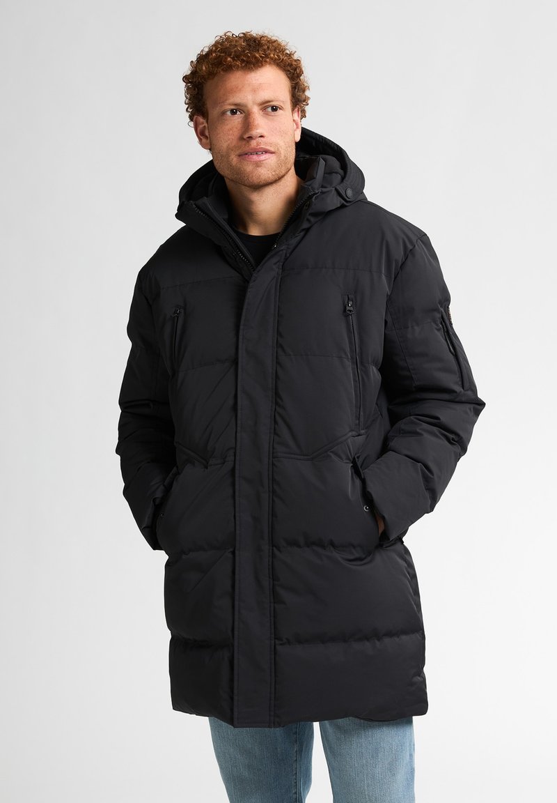 Abrigo acolchado negro con capucha, que cuenta con cierre de cremallera en el frente, dos bolsillos laterales y un bolsillo en la manga. Textura suave y diseño acolchado.