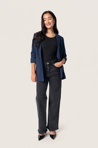 Navy blazer, ribbed black top, high-waisted black wide-leg jeans, pointed black heels, model standing, neutral background.