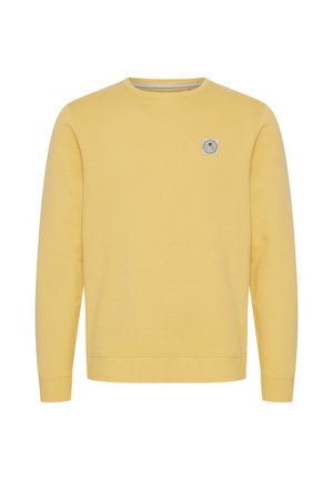 Sweat-shirt jaune à manches longues avec col rond, poignets côtelés et petit écusson carré avec logo sur le côté gauche de la poitrine.