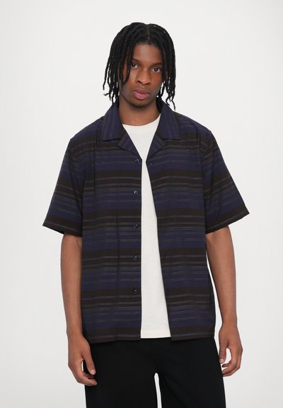 Chemise à manches courtes à bouton avec des rayures bleu marine foncé et noires rehaussées de fines accents jaunes. Fabriquée en tissu léger avec un col classique.