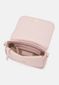 Borsa in pelle rosa con una finitura testurizzata, hardware oro e una tasca interna con zip. La patta aperta rivela un ampio scomparto principale.