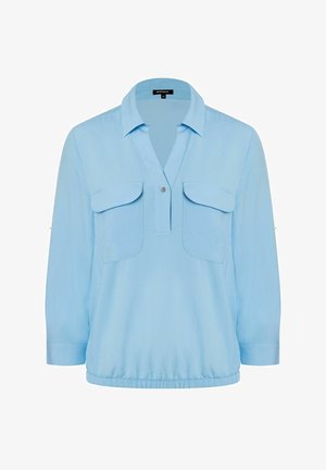 Lichtblauwe blouse met lange mouwen en kraag, twee borstflappenzakken, een halve knopenbies met drukknop en een elastische zoom.