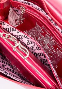 Borsa sintetica rosa con accenti metallici argentati. L'interno presenta più scomparti, uno con un design decorativo sulla fodera in tessuto.