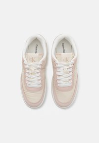 Calvin Klein sneakers with light pink and cream leather upper, white laces, padded collar, and logo detail on tongue. Textured finish.