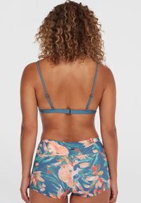 Blommig bikini-set med en justerbar topp i blått och ett högmidjat underdel med ett livligt blommönster på en blå bakgrund.
