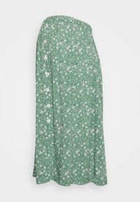 Grön midi-kjol med vitt blommönster, som har en rad knappar på vänster sida och en A-linjeformad silhuett.