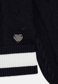 Maglione nero con motivi a cuore e lavorazione a maglia strutturata. Presenta un'etichetta logo argentata a forma di cuore e righe bianche all'orlo.
