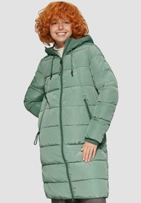 Manteau gonflé vert avec fermeture éclair à l'avant, capuche à cordon de serrage et poignets côtelés. Présente un matelassage horizontal et deux poches latérales.
