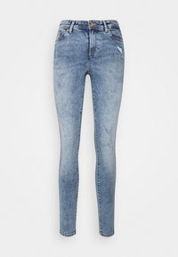 Jeans ajustados en denim azul claro con una textura desgastada y ligero desgastado en la pierna derecha. Presentan un cierre estándar de botón y cremallera.