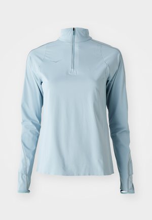 Haut de sport à manches longues bleu clair avec un col zippé mi-hauteur, texture lisse et couture grise contrastante le long des coutures.