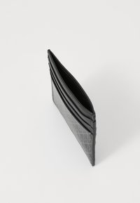 Porte-cartes noir en cuir texturé, comportant plusieurs emplacements pour cartes et un design mince avec un motif géométrique sur un côté.