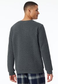 Grijze gewatteerde sweatshirt met een ronde hals en ribgebreide manchetten. Bevat een textuur met een ruitpatroon en heeft een relaxed fit ontwerp.