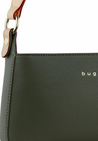 Borsa a tracolla in verde oliva texture con una tracolla in pelle liscia, hardware dorato e branding sottile in carattere metallizzato.